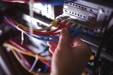 Close-Up of technician plugging patch cable in a rack mounted server i